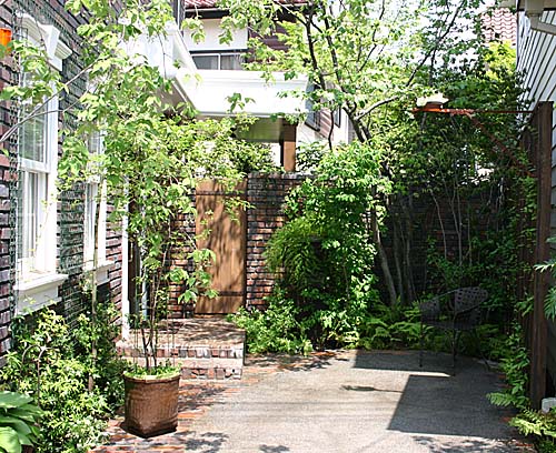 玄関アプローチと中庭との間にアンティークレンガの曲線を持った塀